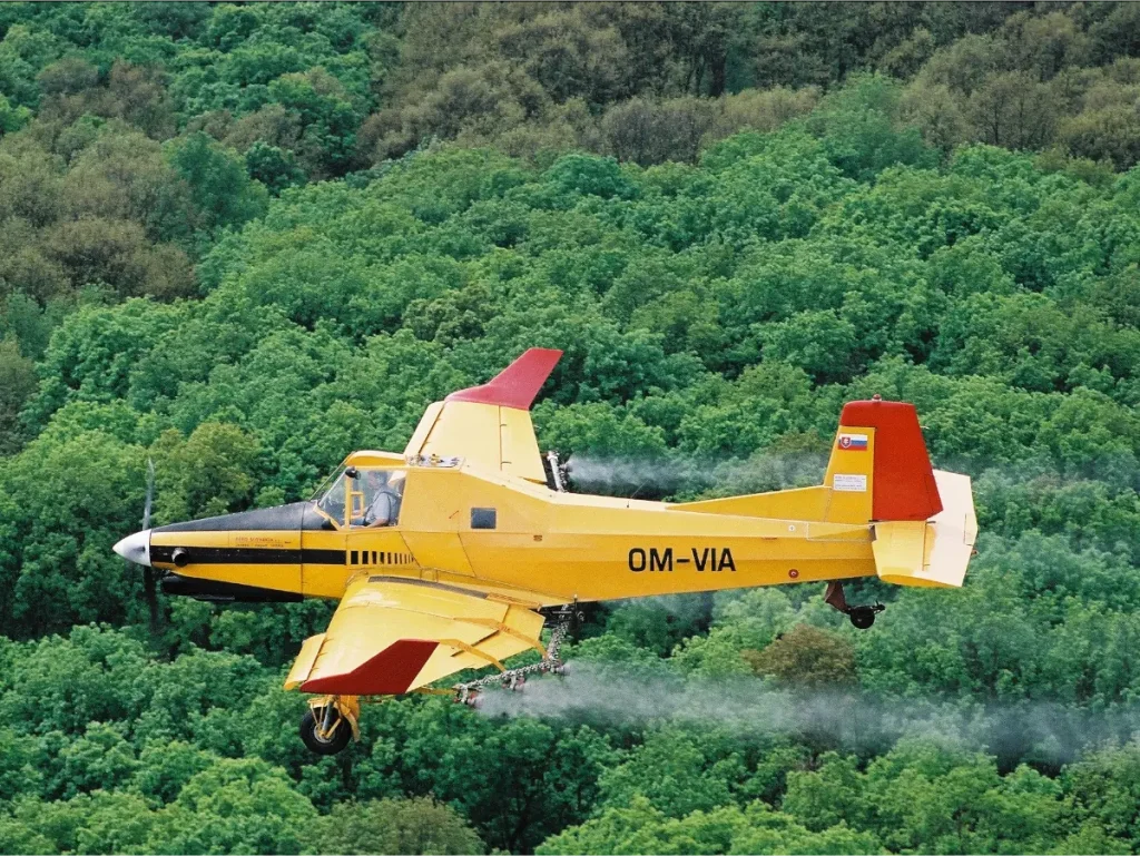 AU4000 aerial atomisers mounted on a fixed wing aircraft applying pesticide in forestry